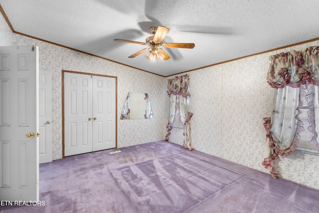 unfurnished bedroom with crown molding, carpet, and ceiling fan