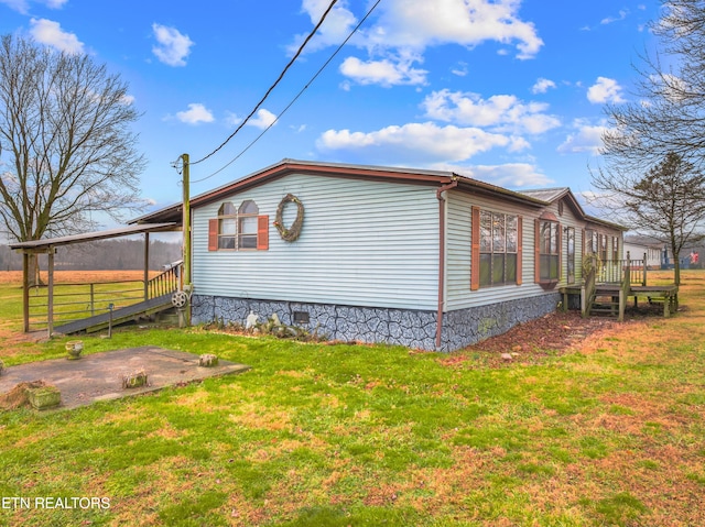 view of side of property featuring a yard and a deck