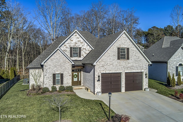 view of front facade featuring cooling unit, a garage, and a front yard