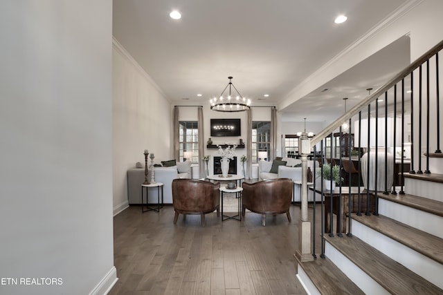 living room featuring dark hardwood / wood-style flooring, crown molding, and a chandelier