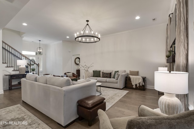 living room featuring crown molding, a notable chandelier, and hardwood / wood-style flooring