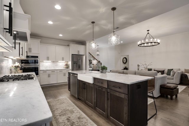 kitchen with white cabinetry, sink, a large island with sink, and appliances with stainless steel finishes