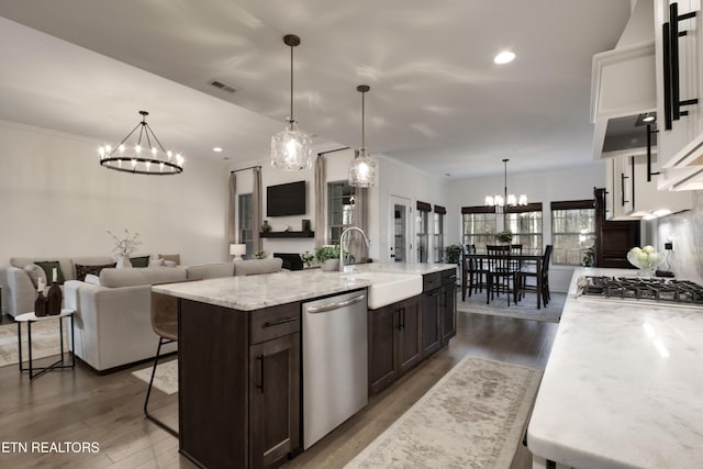 kitchen featuring sink, a kitchen bar, hanging light fixtures, stainless steel appliances, and a spacious island