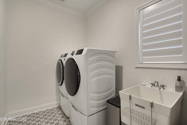 washroom featuring sink, ornamental molding, and washing machine and clothes dryer