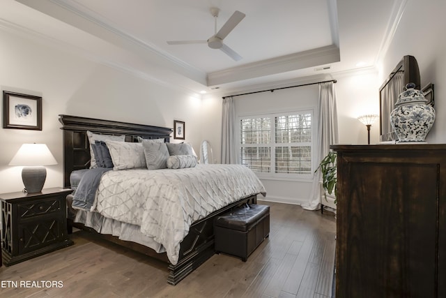 bedroom featuring hardwood / wood-style floors, ornamental molding, a raised ceiling, and ceiling fan