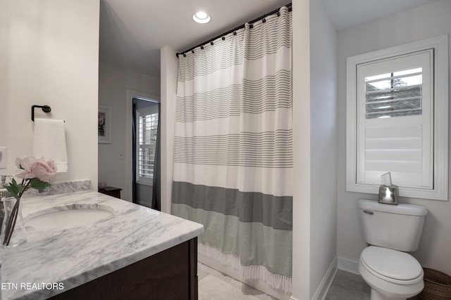 bathroom featuring vanity, walk in shower, and toilet