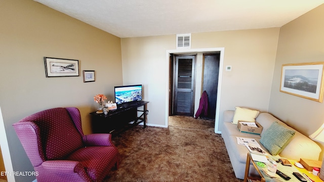 living area featuring dark carpet