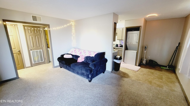 living area with light colored carpet and stacked washer and clothes dryer