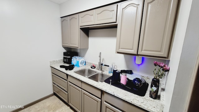 kitchen with sink, light stone countertops, and light tile patterned flooring