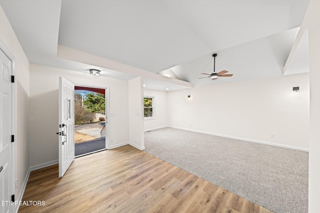 empty room featuring ceiling fan, vaulted ceiling, and light wood-type flooring