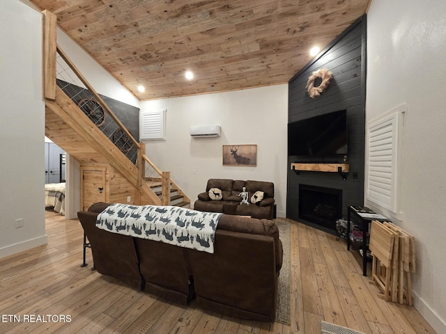 living room featuring an AC wall unit, lofted ceiling, a large fireplace, wood ceiling, and light wood-type flooring