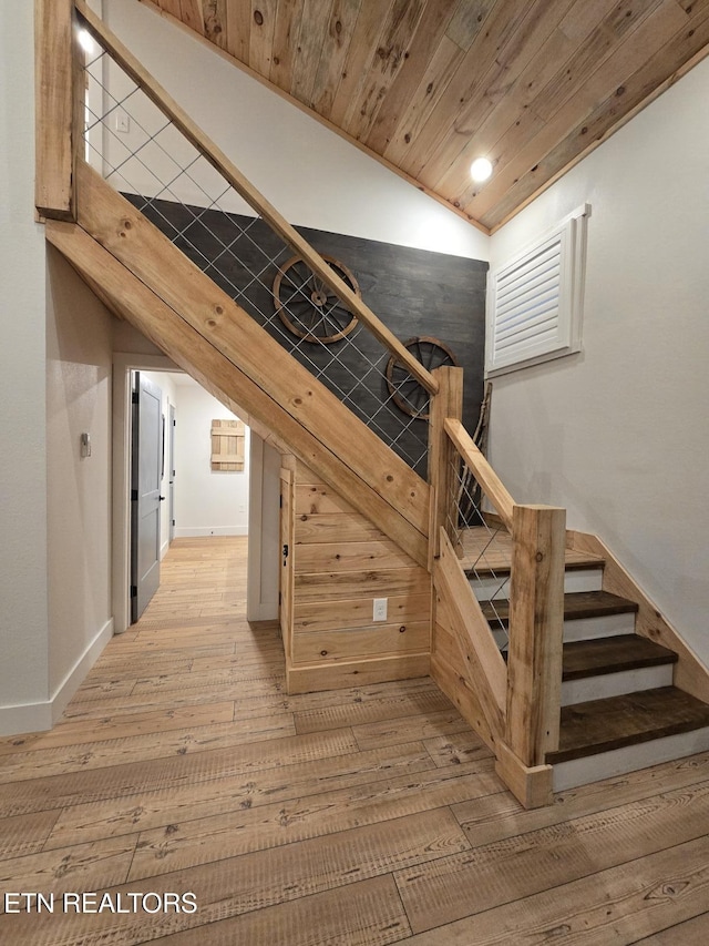 stairway featuring hardwood / wood-style flooring, vaulted ceiling, and wooden ceiling