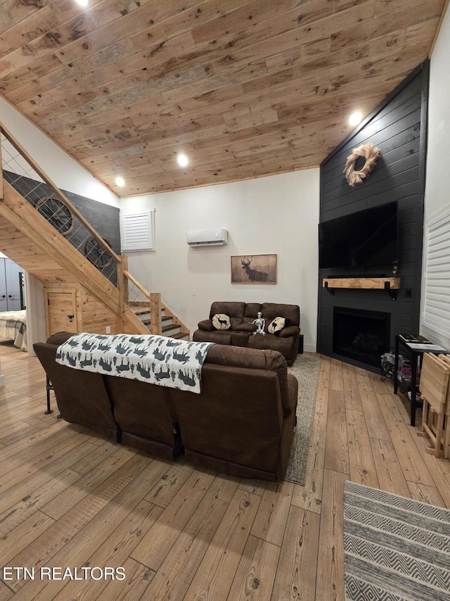 living room with wood ceiling, a large fireplace, hardwood / wood-style floors, and a wall unit AC