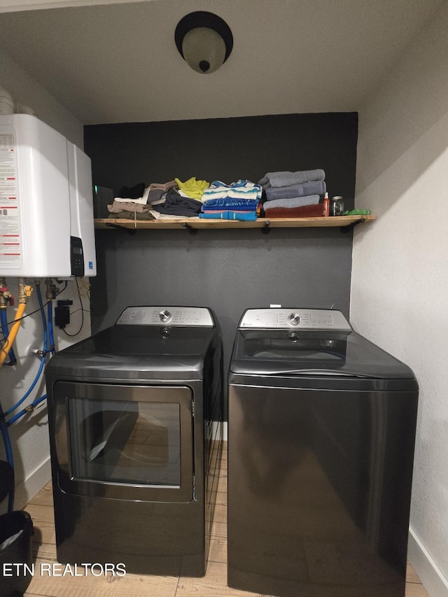 washroom with tankless water heater and washing machine and dryer