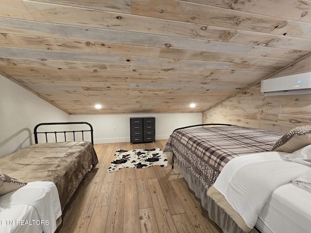 bedroom featuring vaulted ceiling, an AC wall unit, and light wood-type flooring