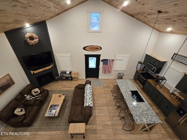 living room with high vaulted ceiling, a fireplace, and wood ceiling