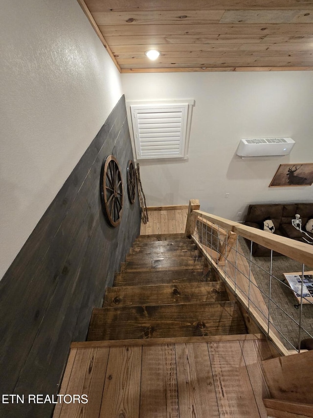 stairway featuring wood-type flooring and wooden ceiling