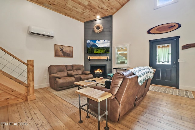 living room featuring a large fireplace, hardwood / wood-style floors, a wall unit AC, a healthy amount of sunlight, and wood ceiling