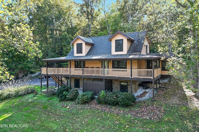 view of front facade featuring a wooden deck and a front lawn