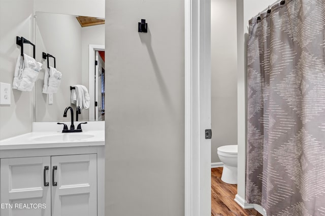 bathroom featuring vanity, hardwood / wood-style floors, and toilet