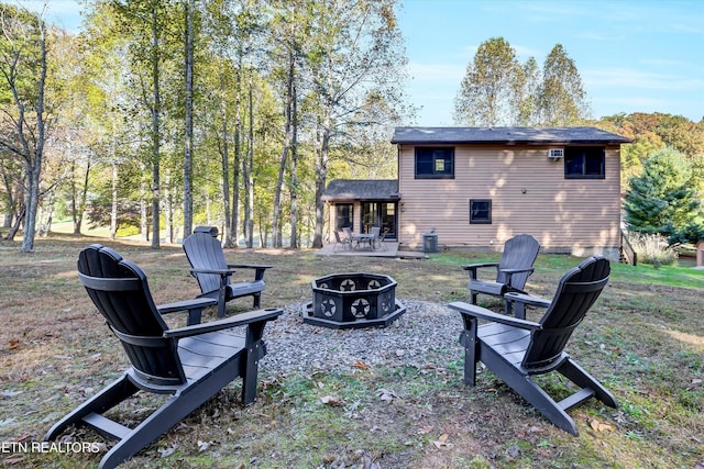 view of yard with central AC unit, a patio, and an outdoor fire pit