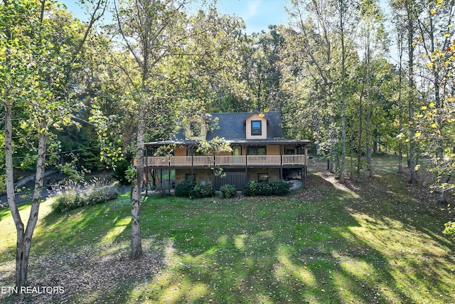 rear view of house featuring a yard and a deck