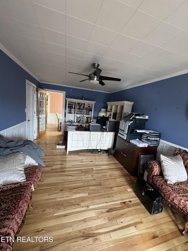 living room with ornamental molding, ceiling fan, and light wood-type flooring