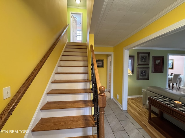 staircase featuring tile patterned floors and ornamental molding