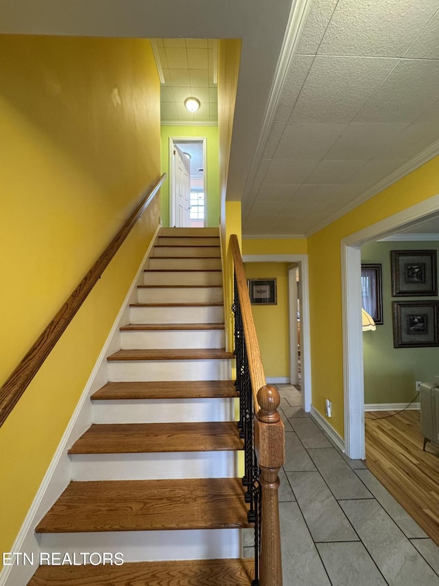 stairs featuring tile patterned flooring and ornamental molding