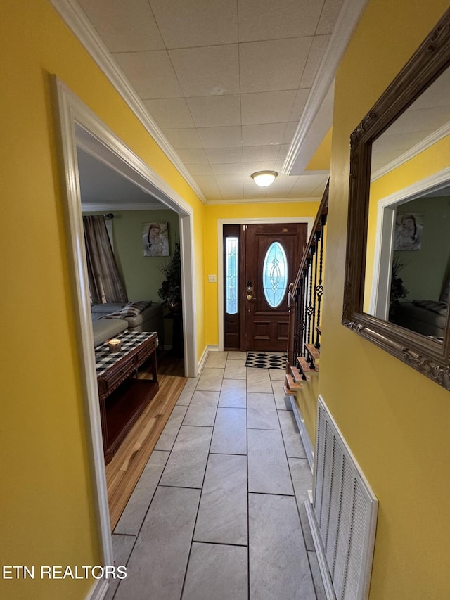 doorway with crown molding and light tile patterned flooring