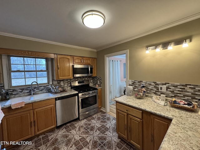 kitchen featuring appliances with stainless steel finishes, sink, backsplash, dark tile patterned floors, and crown molding