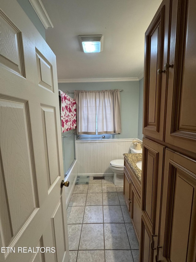 full bathroom featuring crown molding, tile patterned flooring, bath / shower combo with glass door, vanity, and toilet