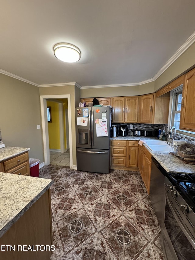 kitchen with crown molding, stainless steel appliances, sink, and dark tile patterned floors