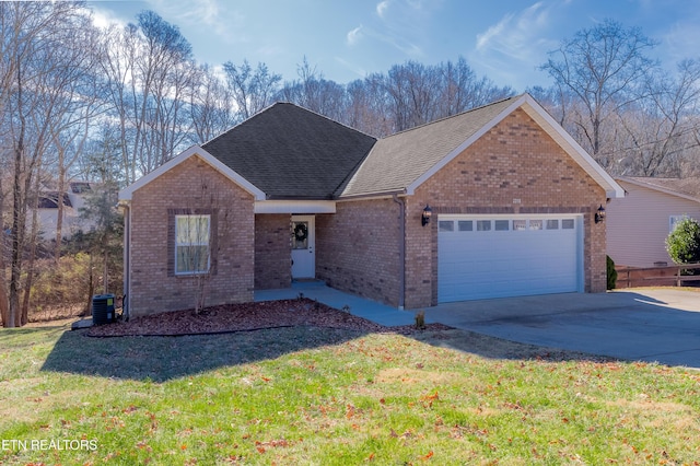 view of front of home with cooling unit, a garage, and a front lawn