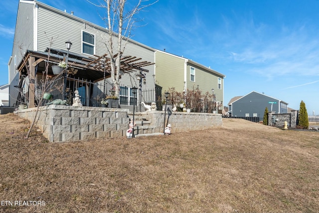 back of property featuring a yard and a pergola