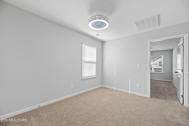 unfurnished bedroom featuring light carpet and a textured ceiling