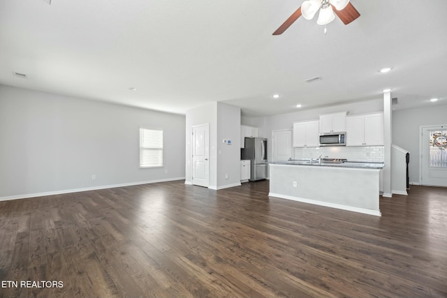 unfurnished living room featuring dark hardwood / wood-style floors and ceiling fan