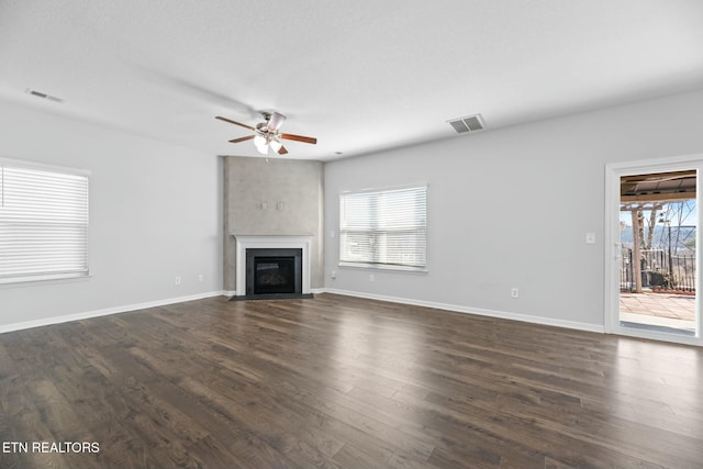 unfurnished living room with dark hardwood / wood-style floors and ceiling fan