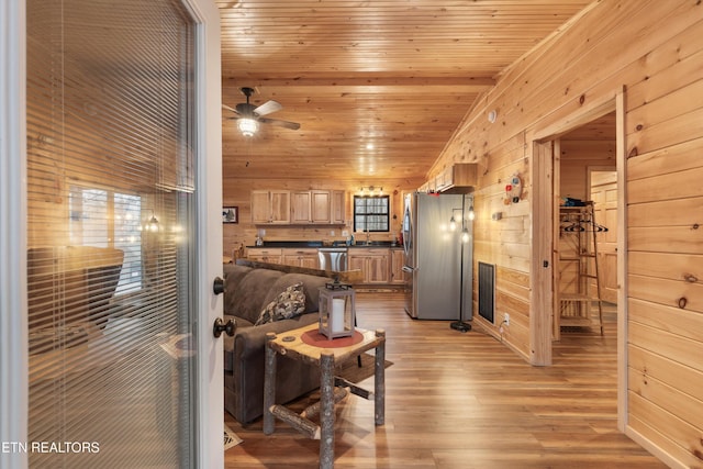 living room with lofted ceiling, wood walls, wood ceiling, light hardwood / wood-style flooring, and ceiling fan