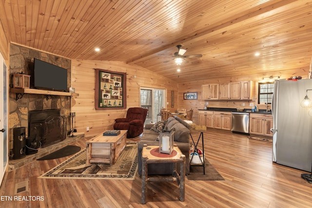 living room featuring lofted ceiling, wood ceiling, light hardwood / wood-style flooring, wooden walls, and a healthy amount of sunlight