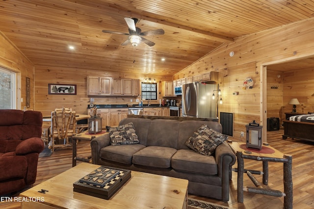 living room with wood ceiling, plenty of natural light, light hardwood / wood-style flooring, and vaulted ceiling with beams