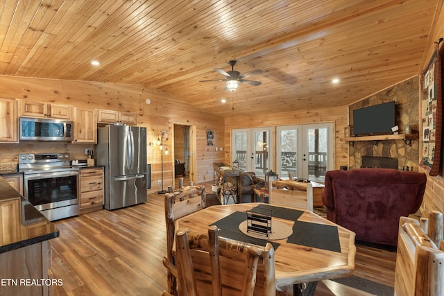 dining space with french doors, lofted ceiling, wooden walls, and hardwood / wood-style floors