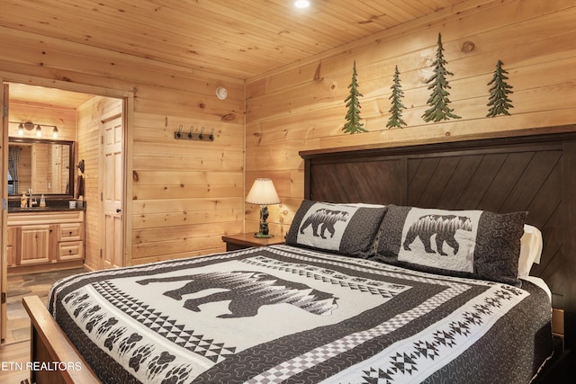 bedroom with connected bathroom, wood ceiling, and wood walls