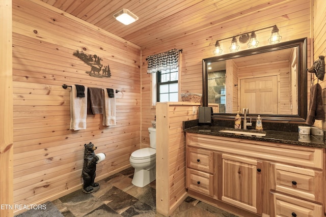 bathroom with vanity, wooden ceiling, wooden walls, and toilet