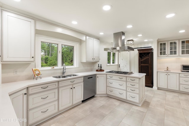 kitchen with sink, white cabinetry, stainless steel appliances, island range hood, and kitchen peninsula