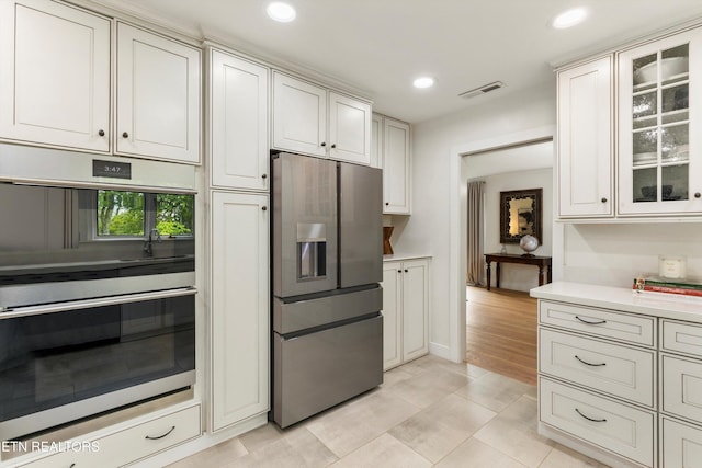 kitchen with white cabinetry, appliances with stainless steel finishes, and light tile patterned floors