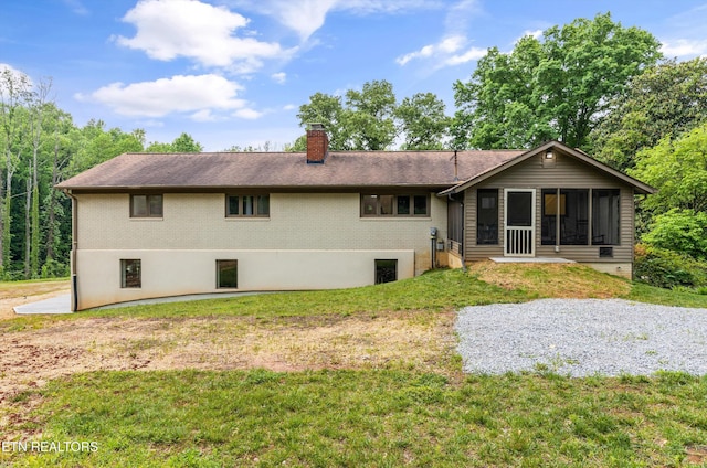 back of house featuring a yard and a sunroom