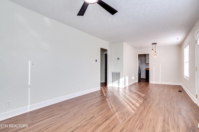 unfurnished living room featuring hardwood / wood-style floors, a textured ceiling, and ceiling fan