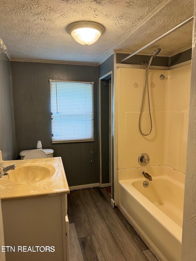 full bathroom with toilet, wood-type flooring, tub / shower combination, a textured ceiling, and vanity