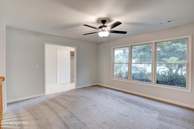 carpeted spare room featuring ceiling fan